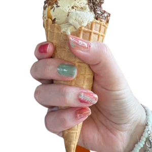 pastel pink and green patterned nail wraps on hand holding ice cream